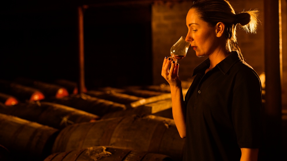 Woman tasting a glass of whiskey